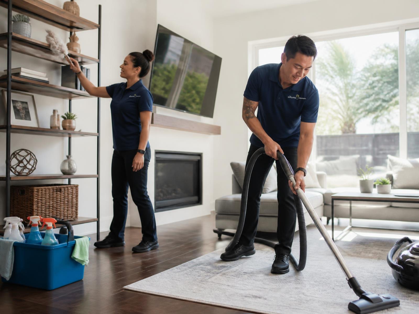 Professional residential cleaners from The Everyday Cleaners in Seattle vacuuming and dusting a living room